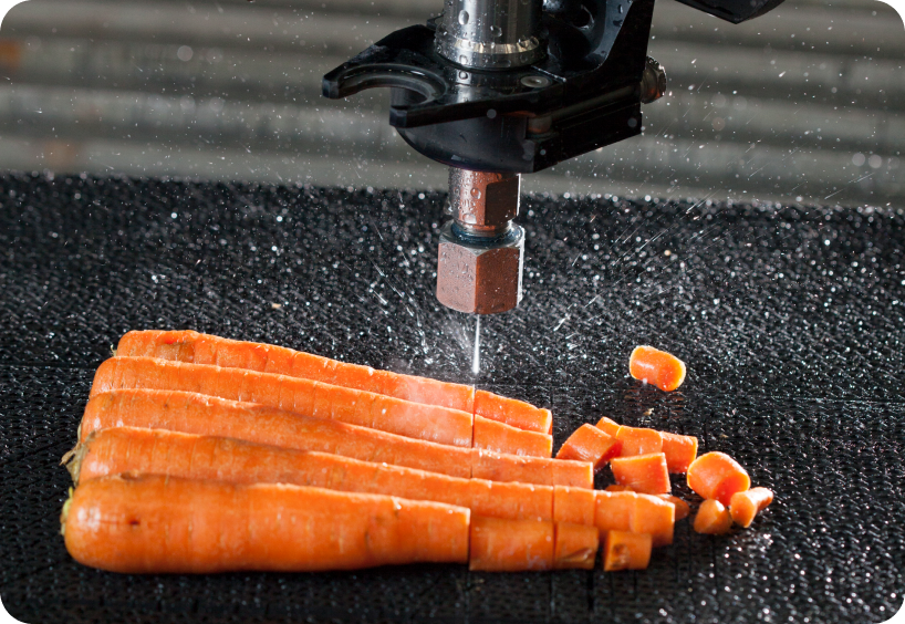 Flow waterjet cutting multiple carrots. Flow systems are great for food processing, slitting, and portioning.
