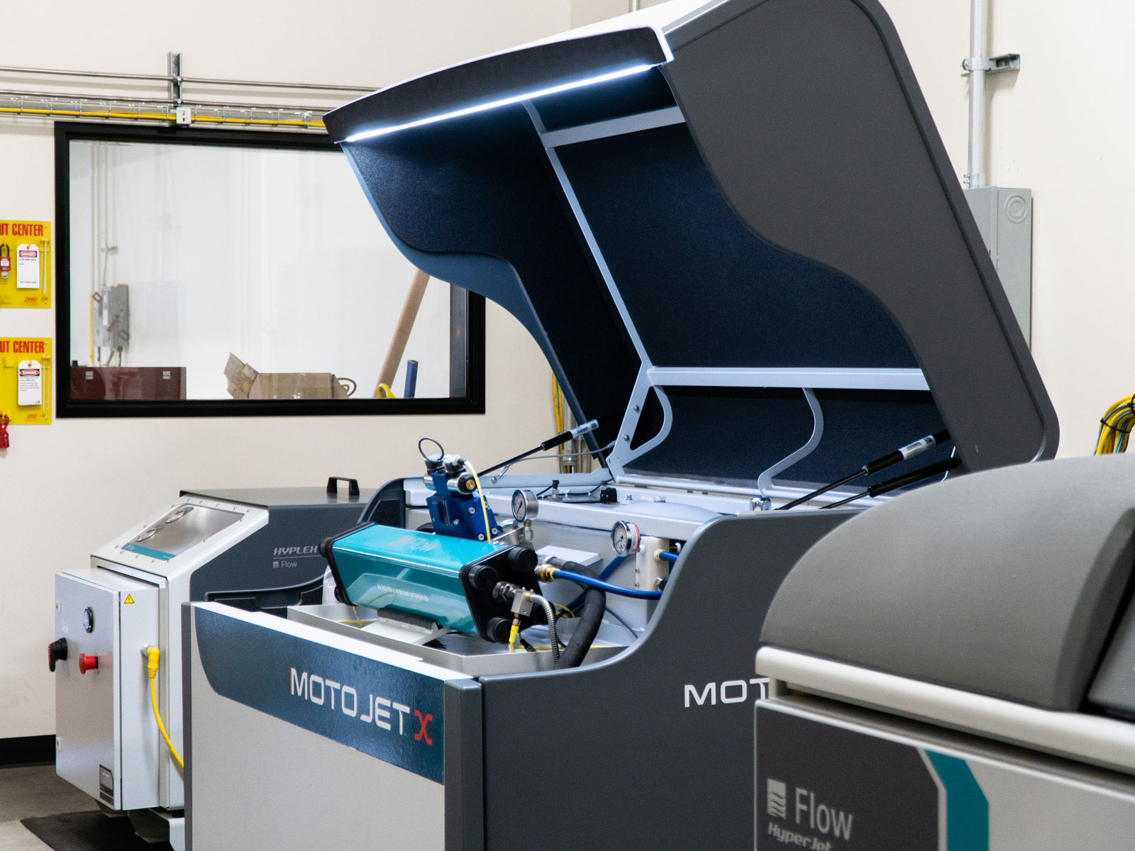 New MotoJet X Intensifier Pump shown with the lid open with integrated work light on showcasing the intensifier and internal components.