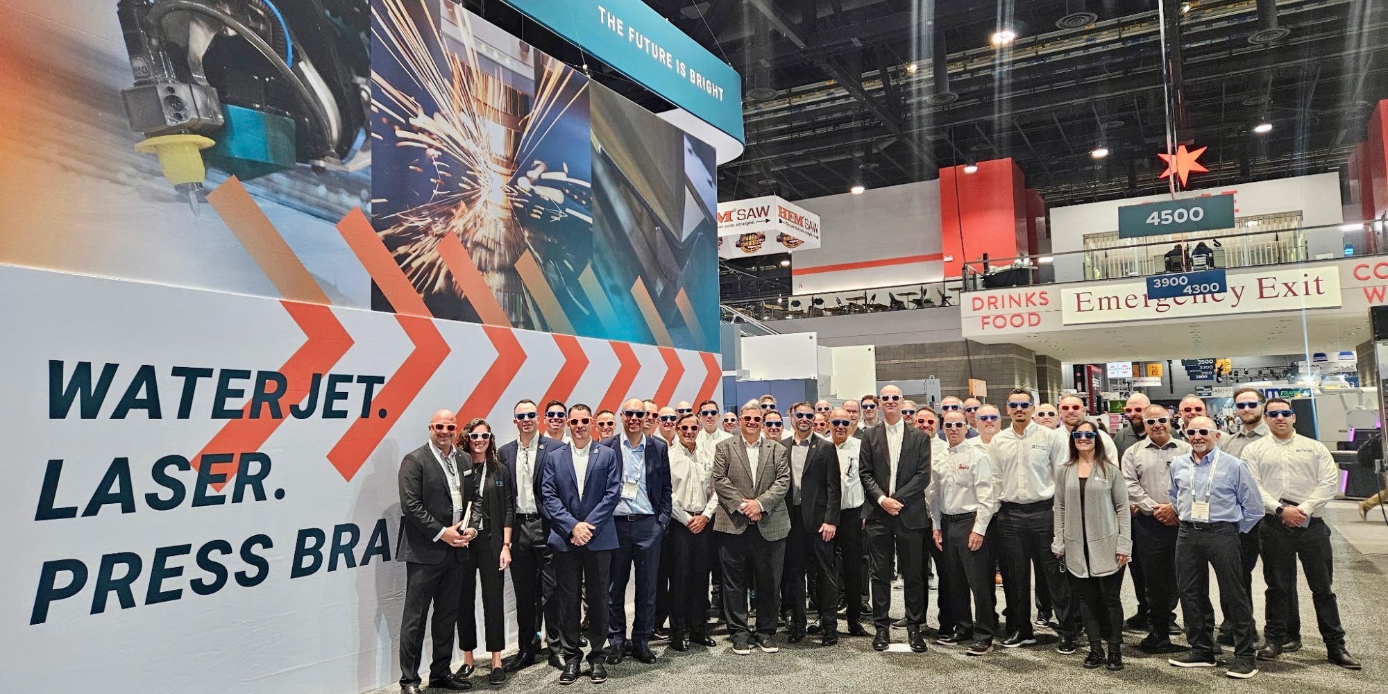 future-is-brigth.png image of large group of Flow employees at Fabtech show 2025 all wearing branded sunglasses