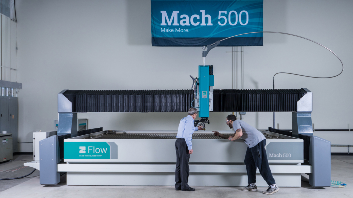 Two men working at a Mach 500 Flow Waterjet machine