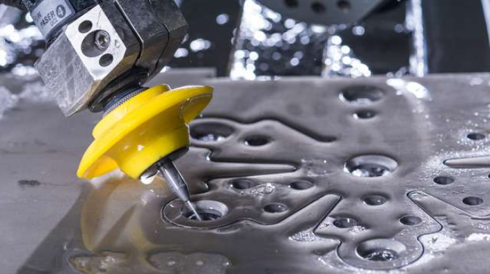 Closeup of waterjet cutting head cutting an intricate pattern in metal